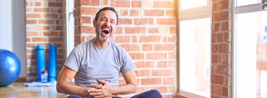 a man laughs as he practices laughter yoga