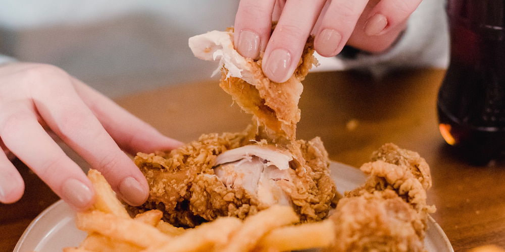 A person eating chicken wings during the Charlotte Mac and Cheese and Wing a Ding Ding Fried Chicken and Wing Festival.