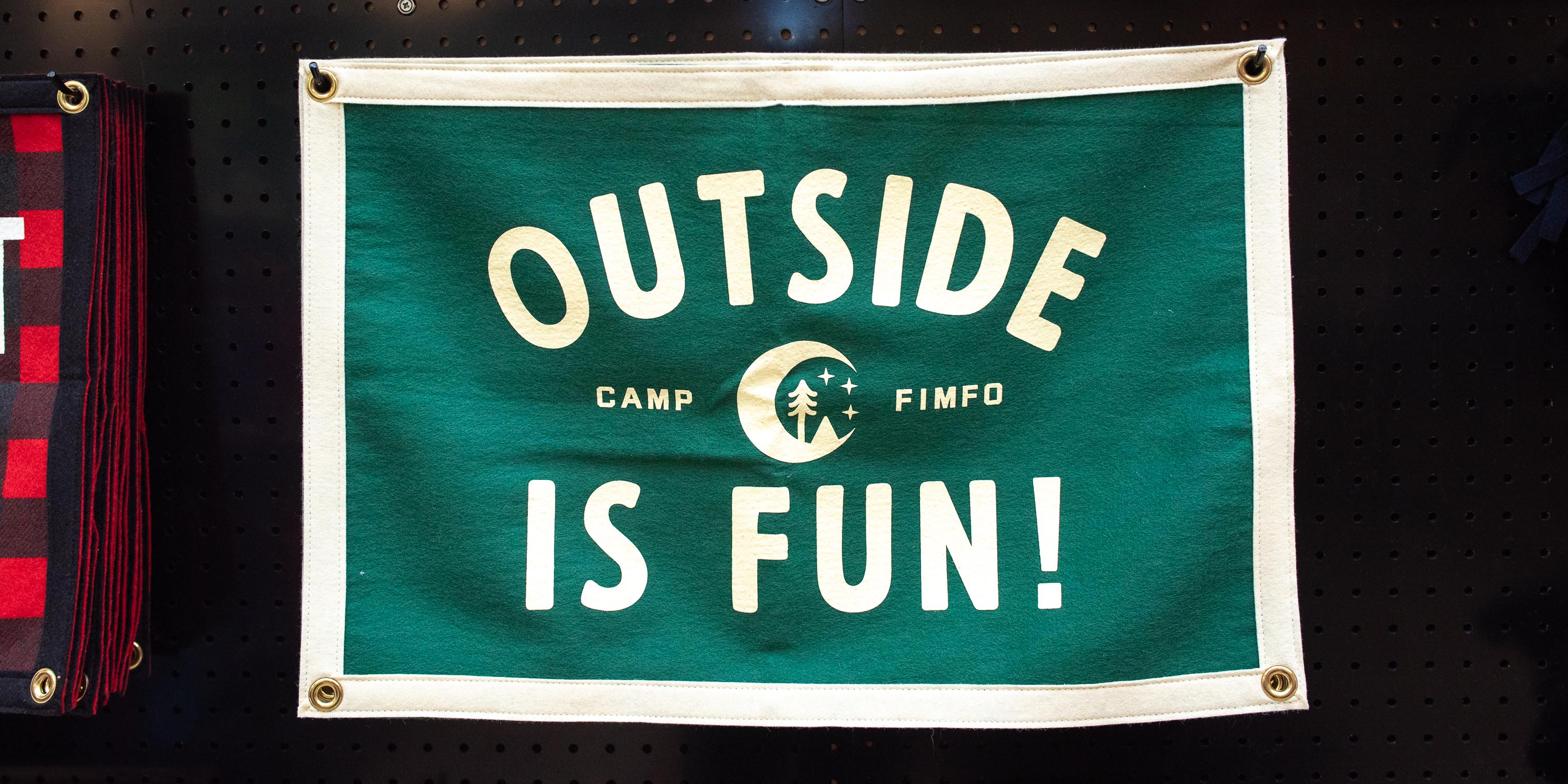 A flag that says "Outside Is Fun" at Camp Fimfo