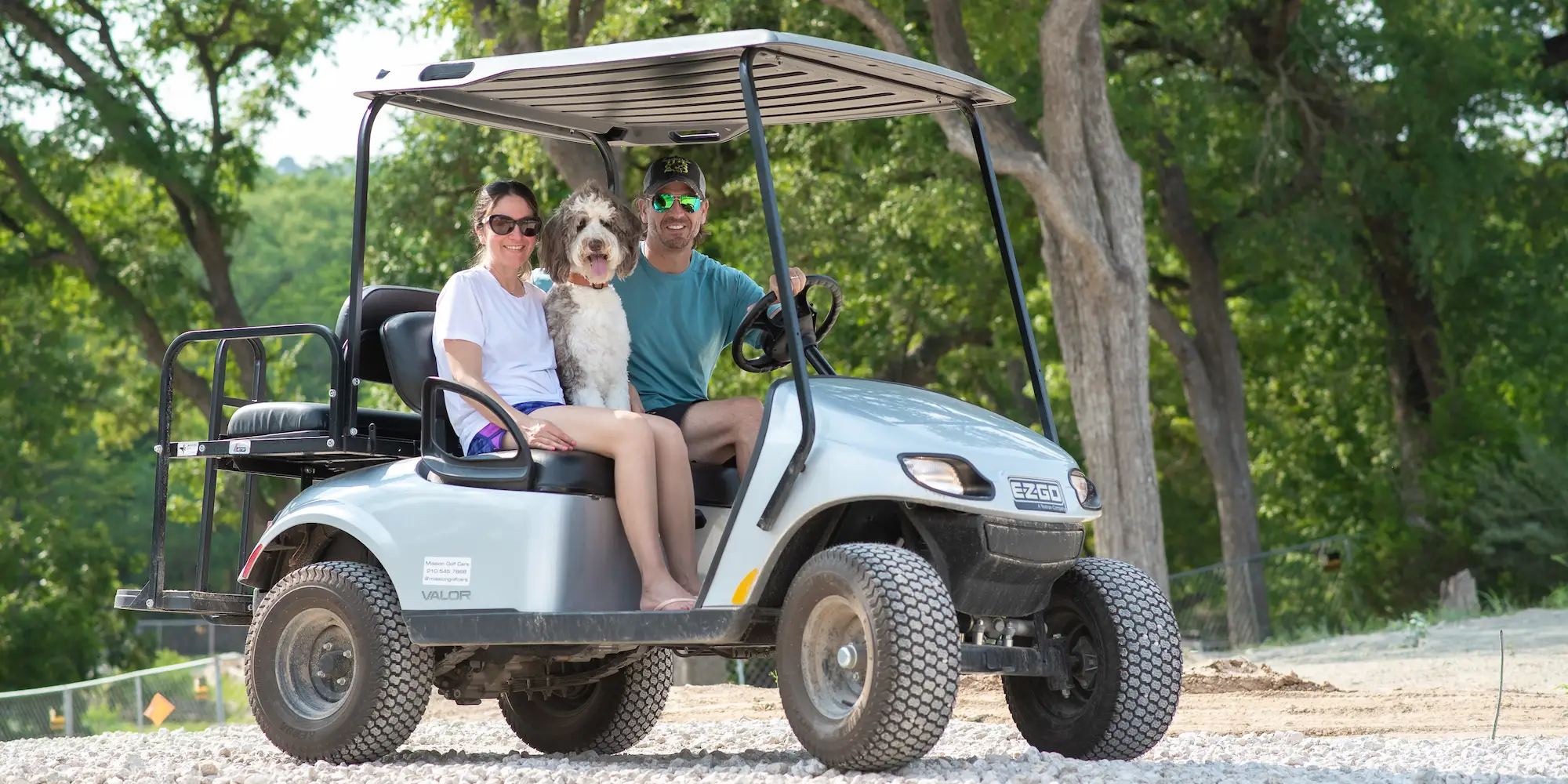 A family riding in a golf cart with their dog at Camp Fimfo Texas Hill Country