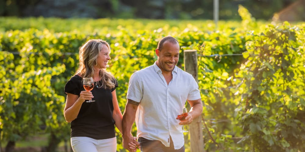 Couple walking in a vineyard during a Traverse City event.