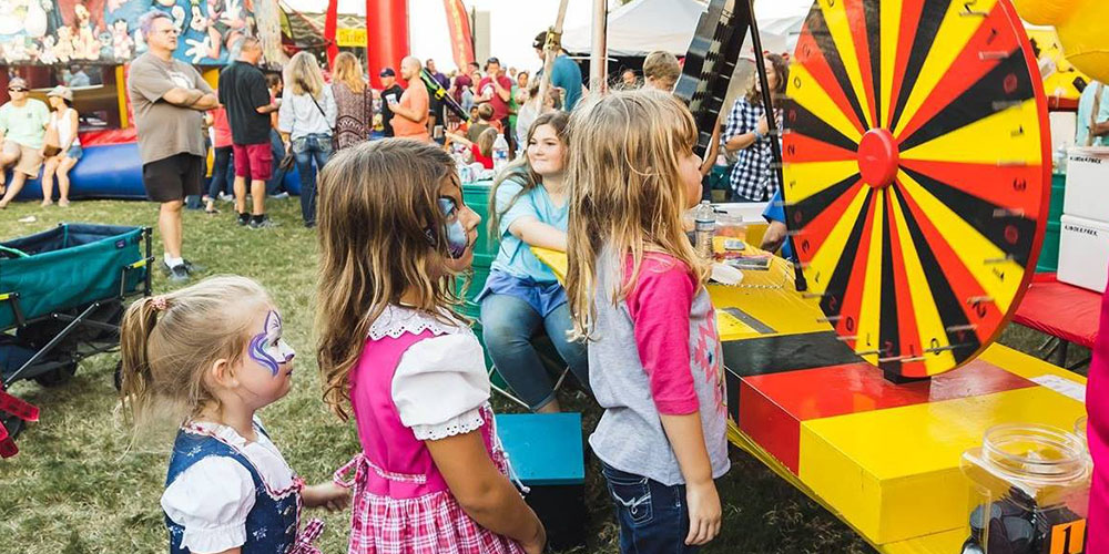 Children lining up to play carnival games during Texas Hill Country's Oktoberfest.