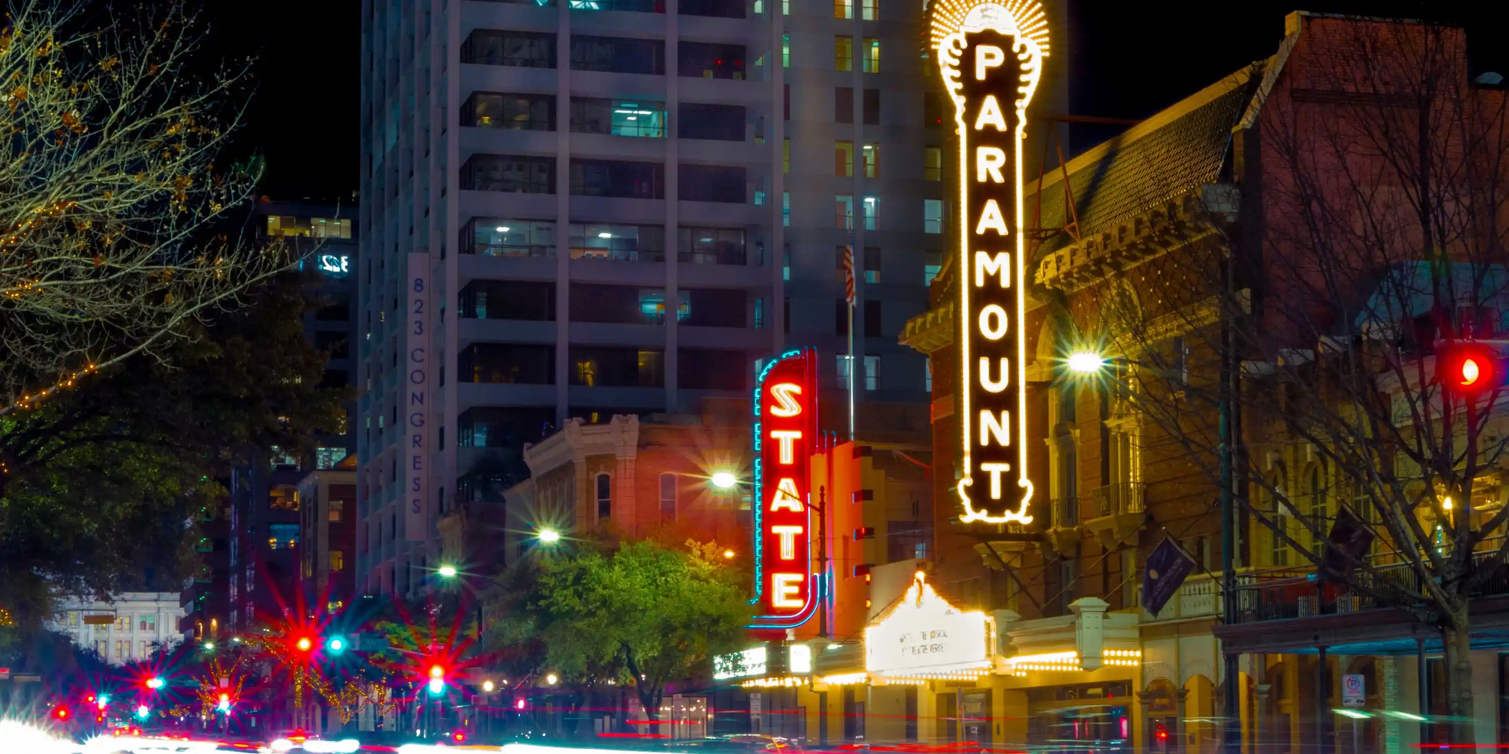 Cars going past the Paramount and State theaters, music venues, in downtown Austin