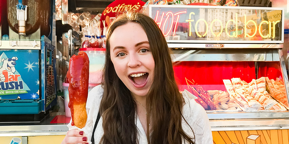 Girl eating corn dog at the Maryland State Fair - a top thing to do in Baltimore with kids.