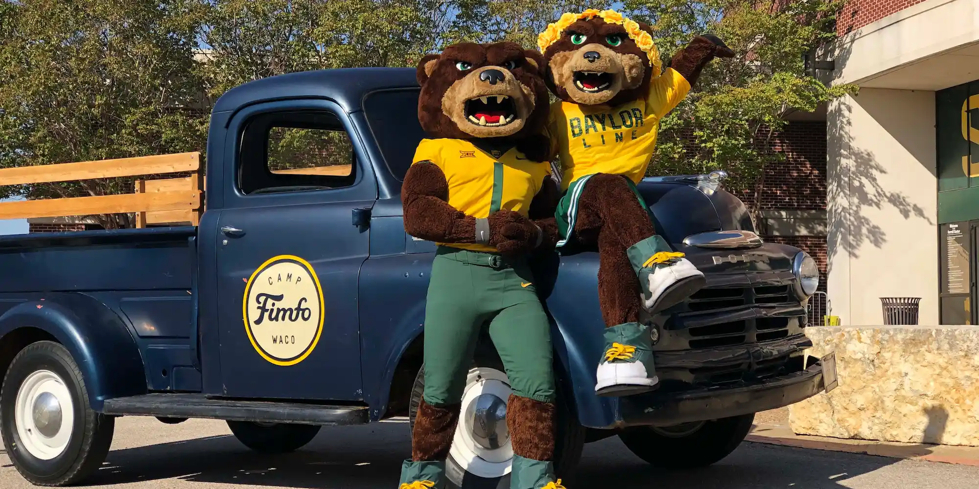 The Baylor Bears mascots, Bruiser and Marigold, posing in front of a Camp Fimfo Waco truck at a Baylor University football tailgate