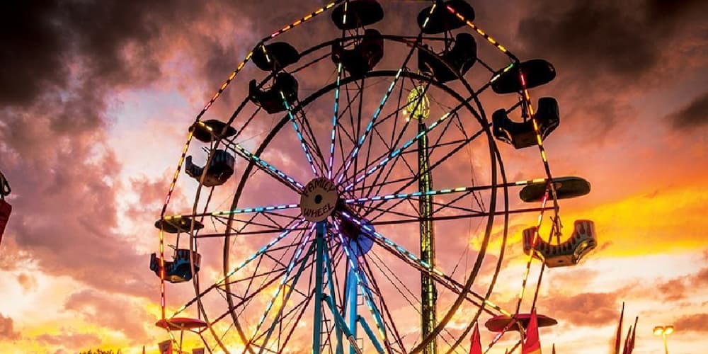 A ferris wheel ride among a sunset at the Mid South Fair in Memphis, TN.