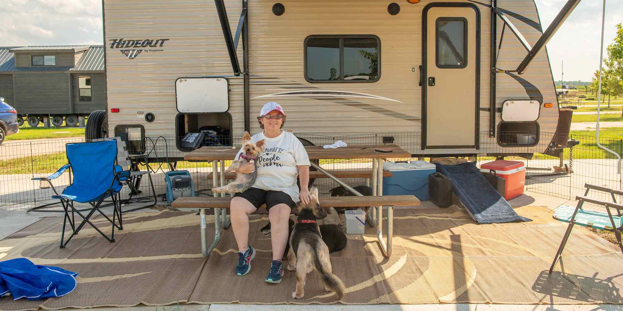 A guest with her two dogs in a pet-friendly RV site at Camp Fimfo Waco