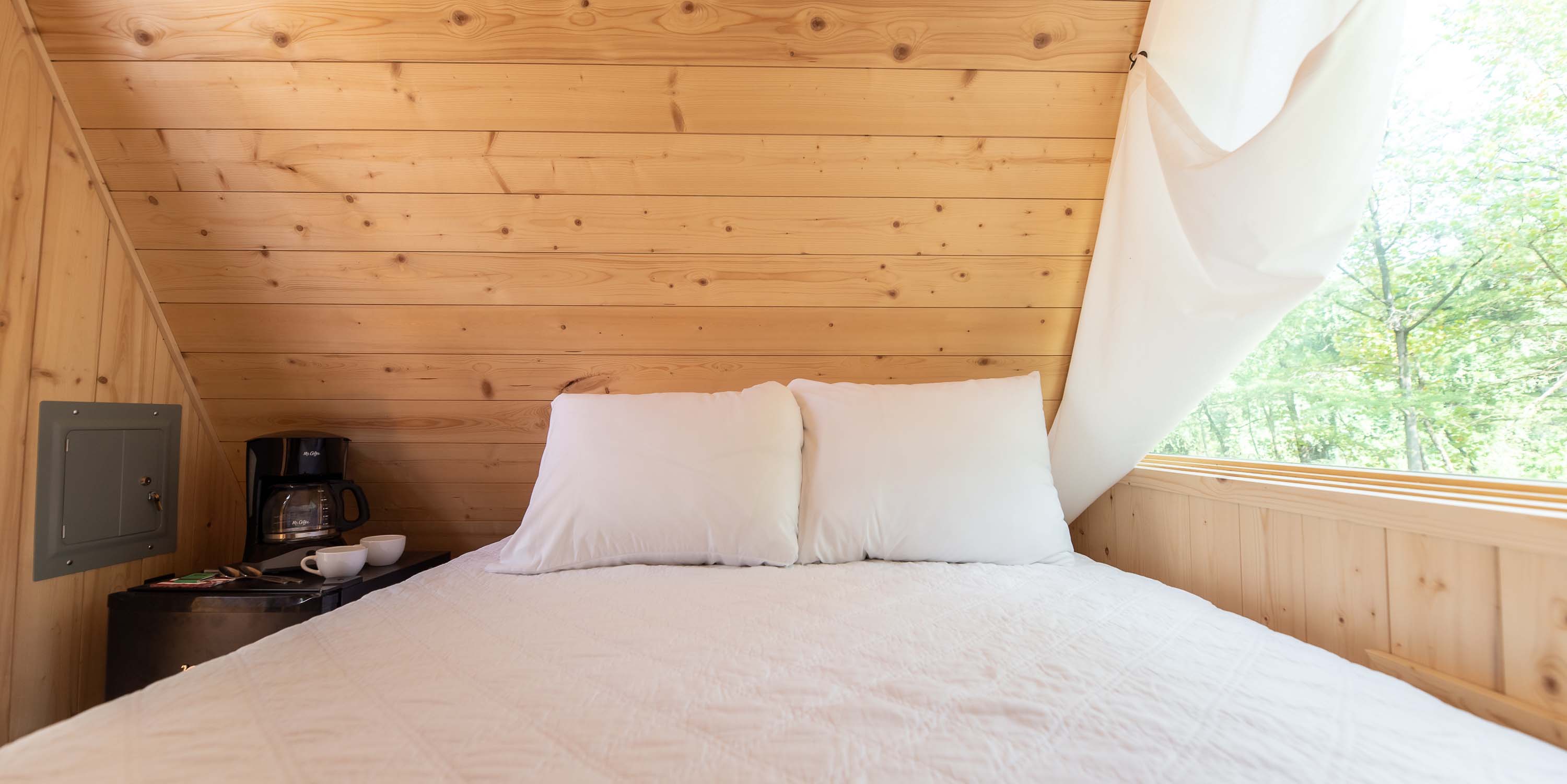 The full size bed with included linens inside a Riverview Cabin at Camp Fimfo Texas Hill Country