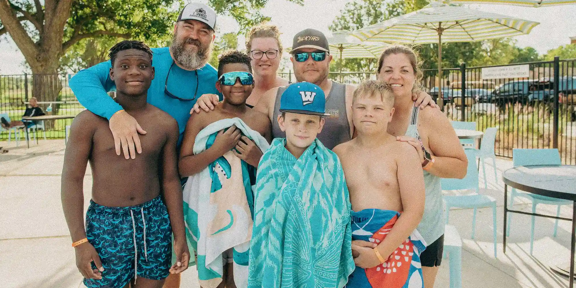 A group of guests posing for a photo at the pool at Camp Fimfo Waco