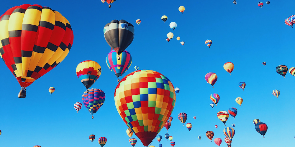 Kick back, relax, and watch the sky filled with colors of different hot air balloons!