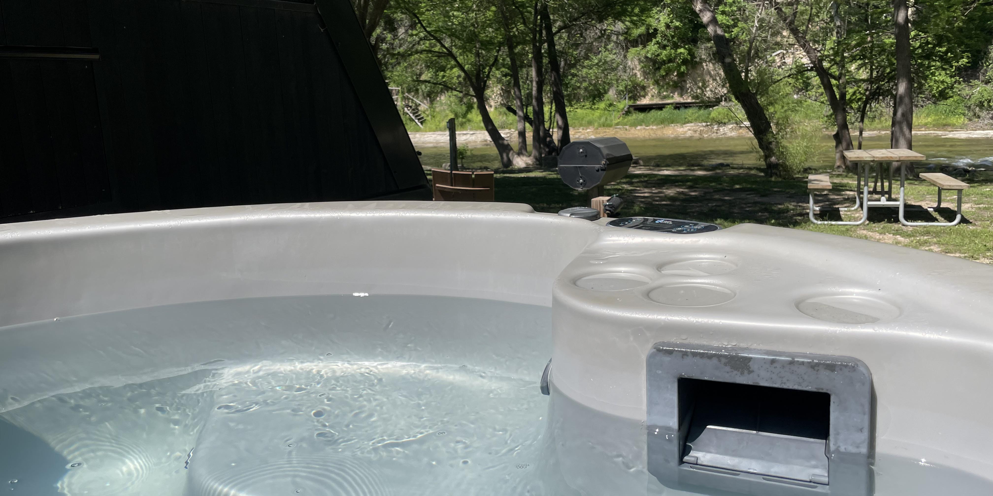 A Riverview Cabin hot tub at Camp Fimfo Texas Hill Country