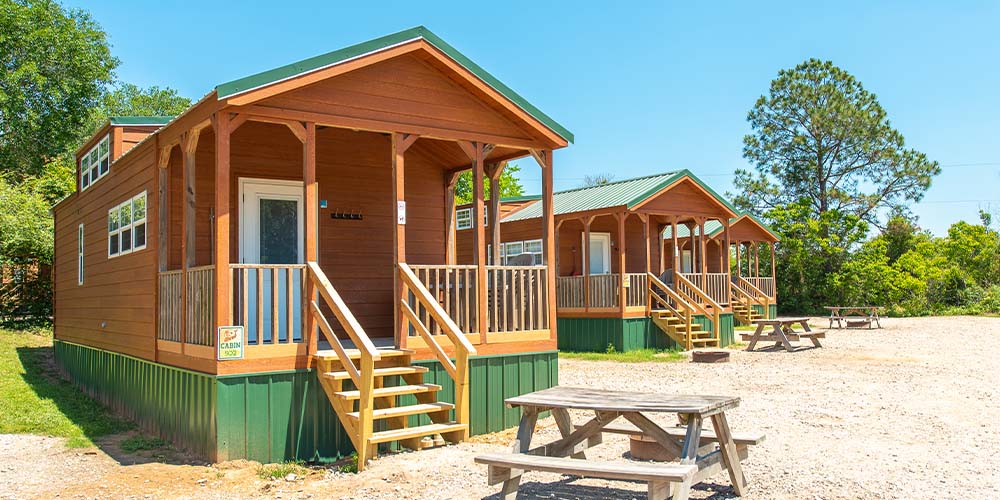 Our Yogi in the Pines Cabins featuring a covered deck, picnic table, and fire pit.