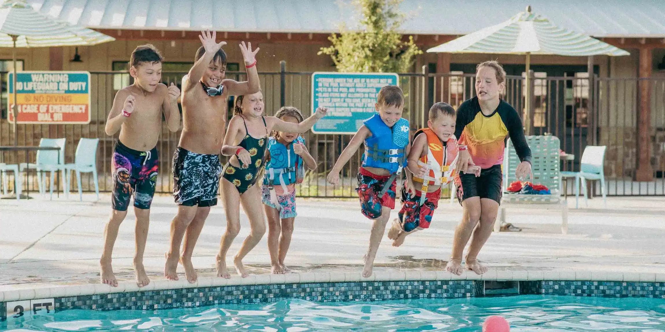 Children jumping into the Camp Fimfo Waco pool 