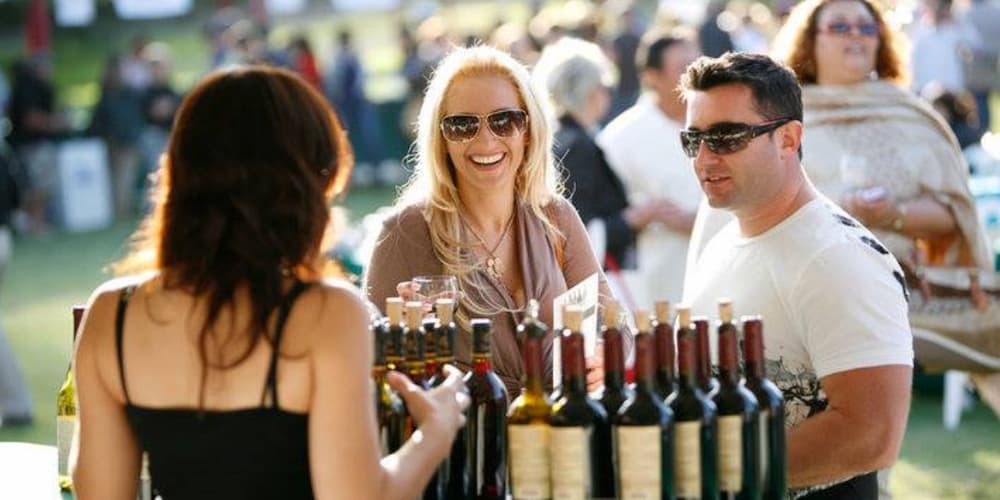 Couple sampling wine at Traverse City's Summer Artisan Art & Wine Walk event.