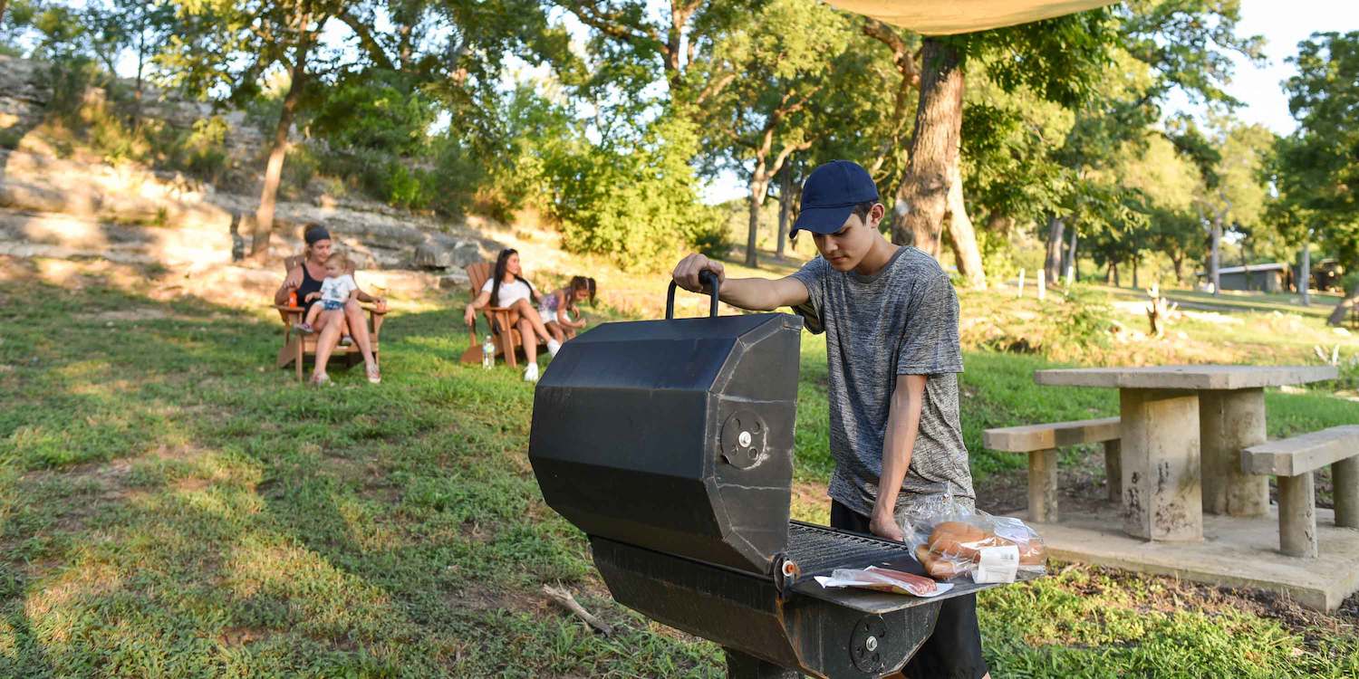 A family grilling at their campsite at Camp Fimfo