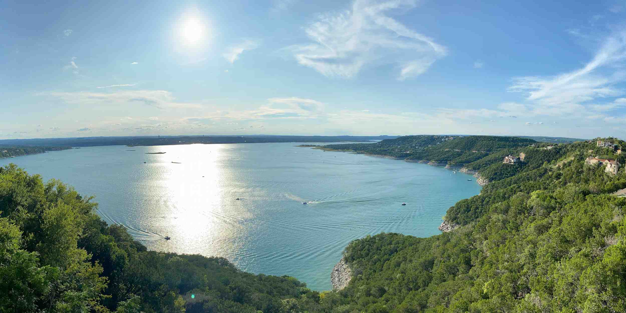 A panoramic view of Lake Travis surrounded with trees, only a short drive from Austin