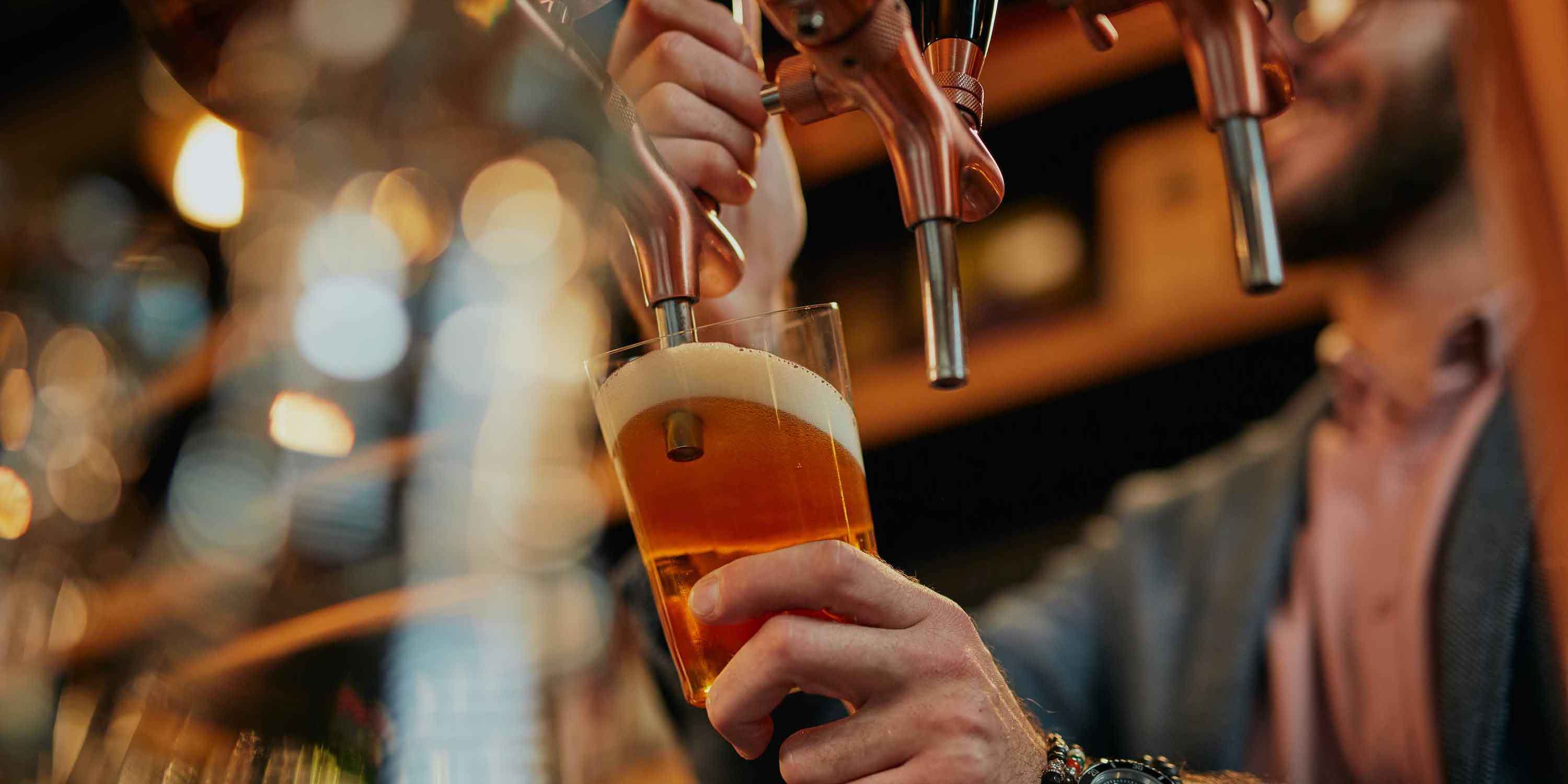A draft beer being poured from the tap at a brewery