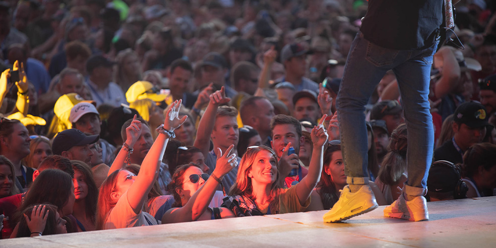 Crowd cheering on Neon Nights, a music festival at Clay's Resort Jellystone Park™.