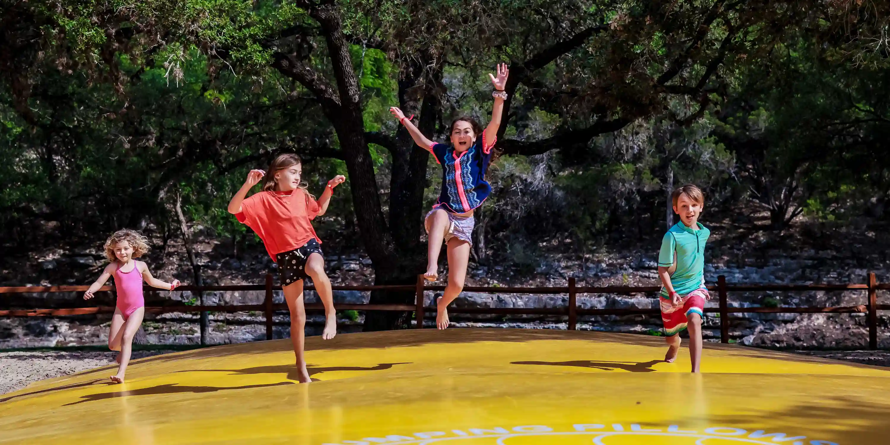 Children bouncing on the jumping pillow at Camp Fimfo