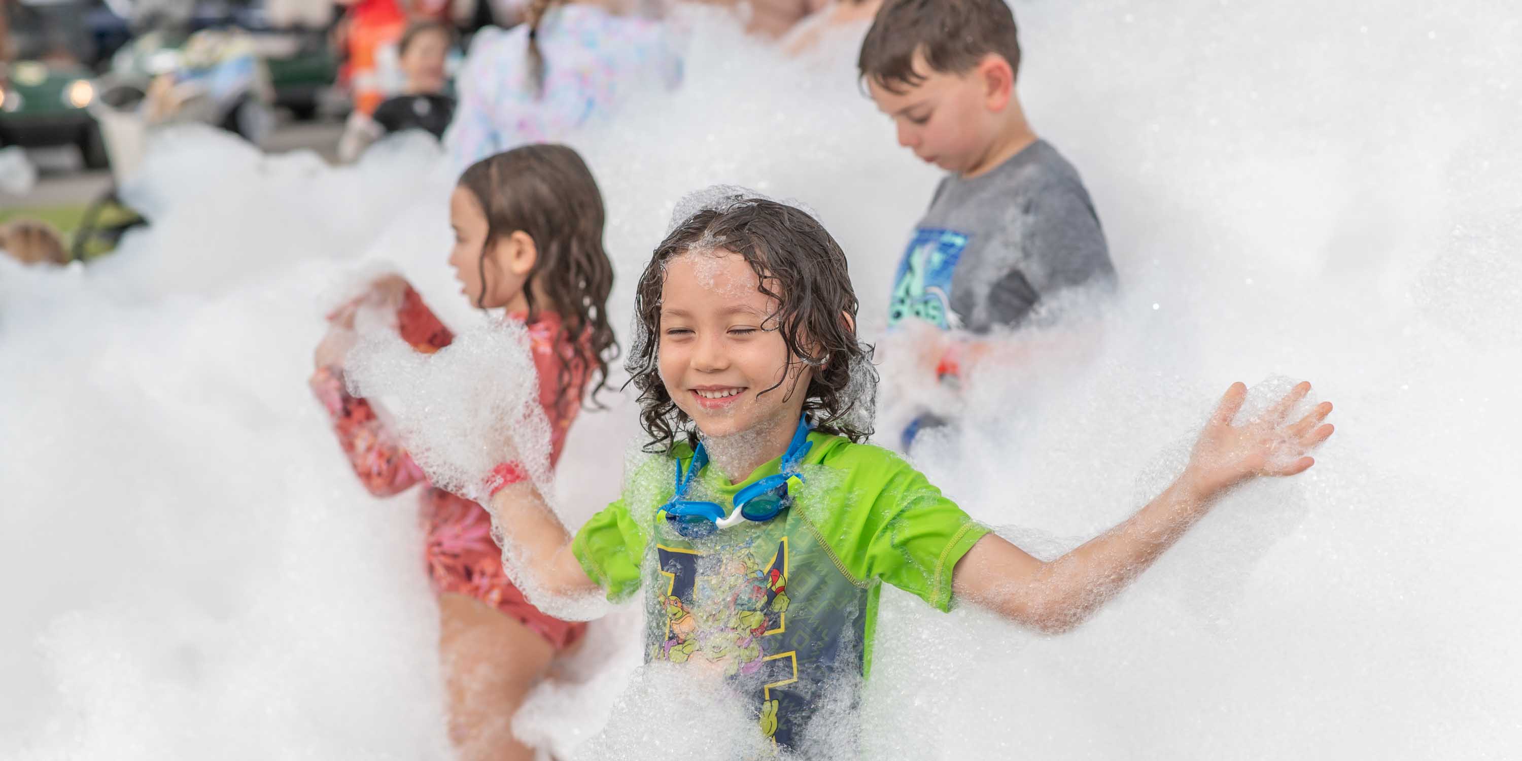 Children having fun in foam at a Camp Fimfo Waco outdoor foam party