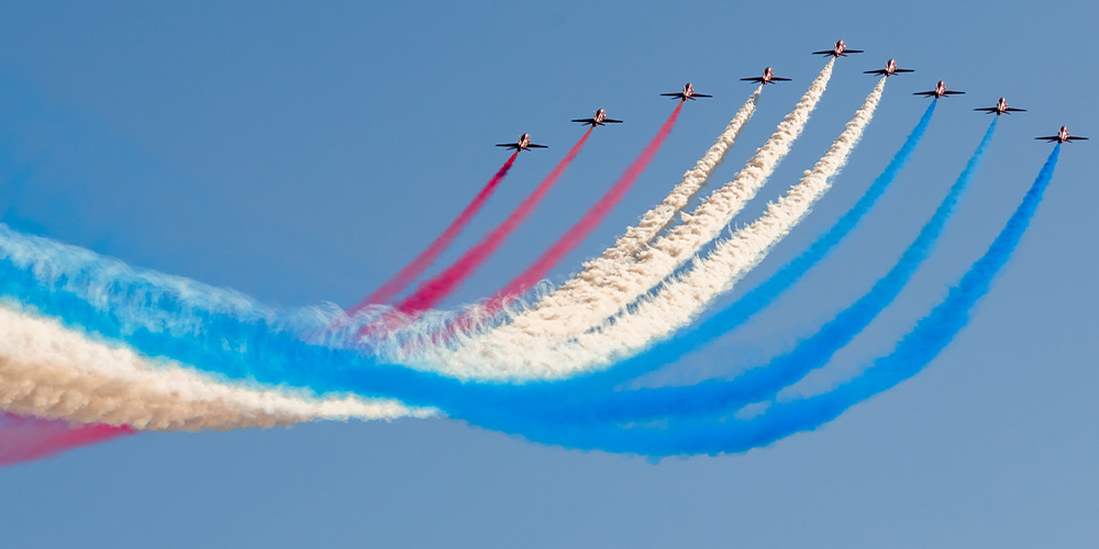 Thunderbirds in the sky showing red, white, and blue.