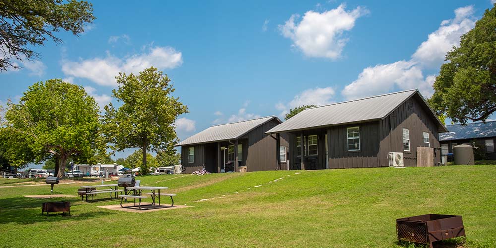 Yogi Bear ™ Cabins surrounded by outdoor space with a picnic table, fire ring, and grill.