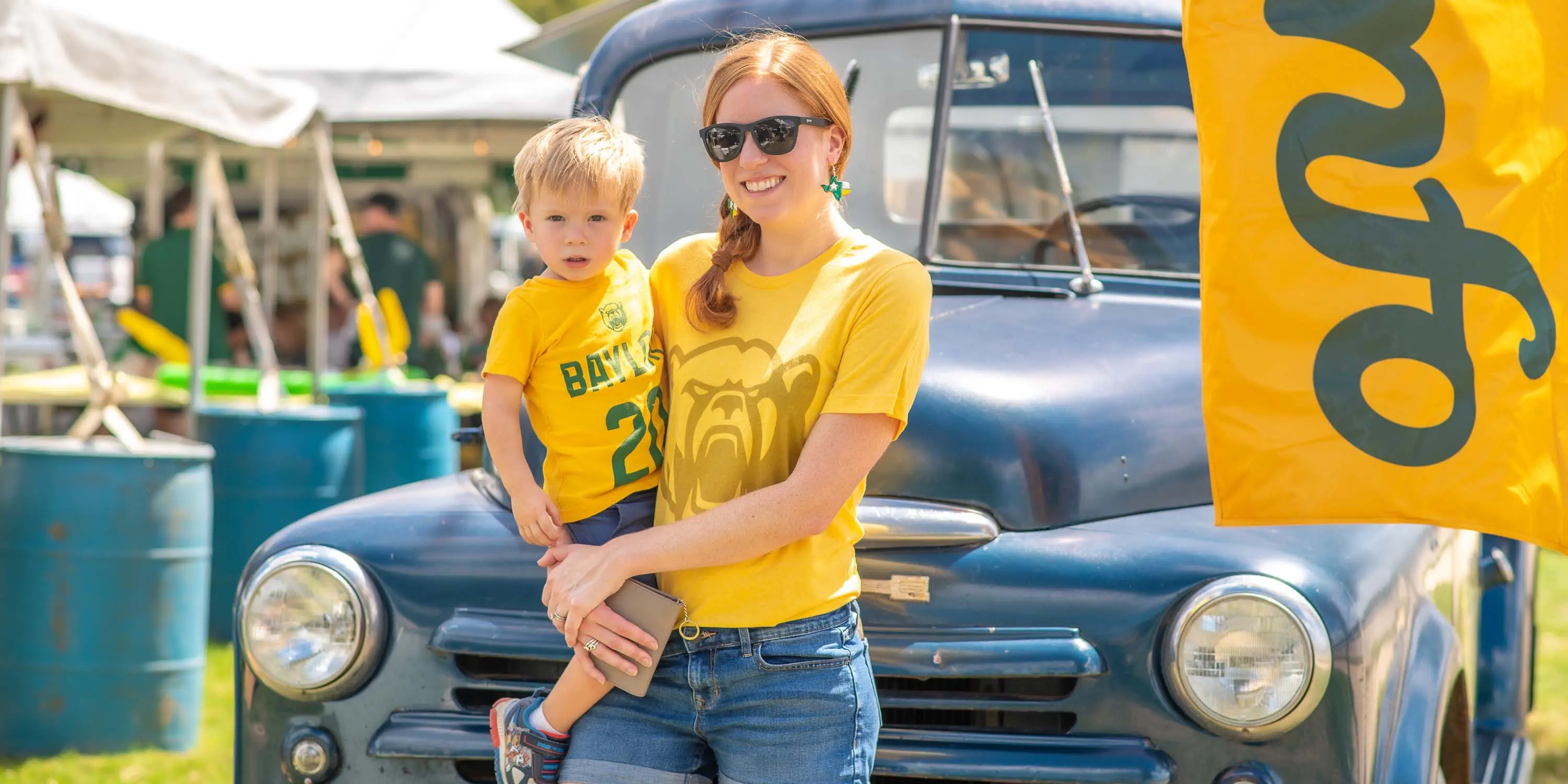 A mother and her child in Baylor University gear at a 2022 Camp Fimfo Waco tailgate