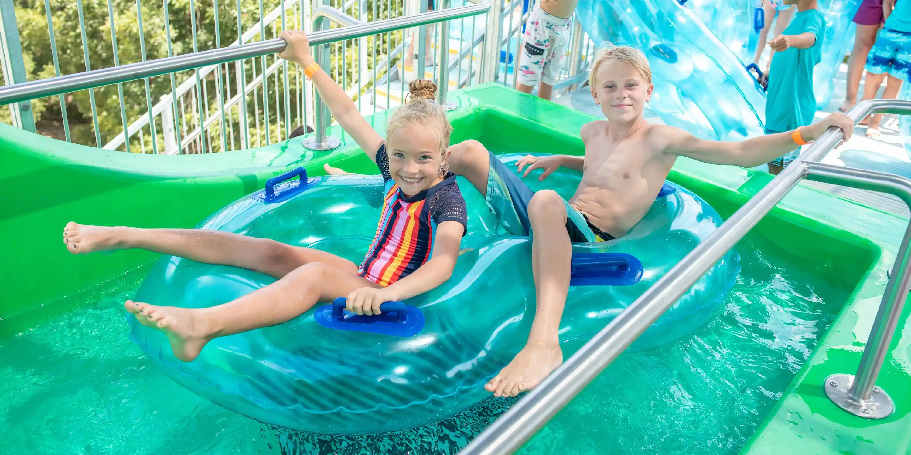 Two children sitting in a tube, waiting to slide down the water slides at Camp Fimfo Texas Hill Country's water playground