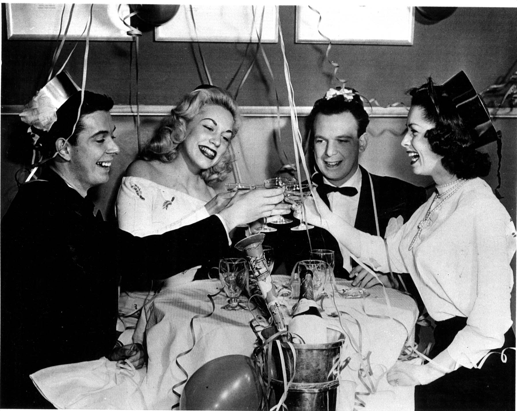 black and white photo of folks from the 50th with festive tops new years eve top hats