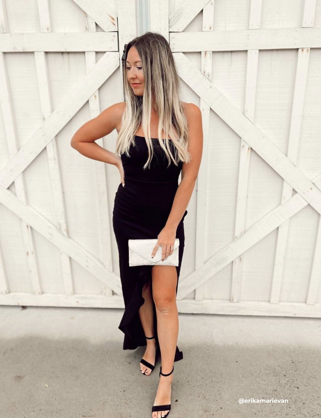 Stylish woman wearing a black ruffle midi dress at a rustic barn wedding.