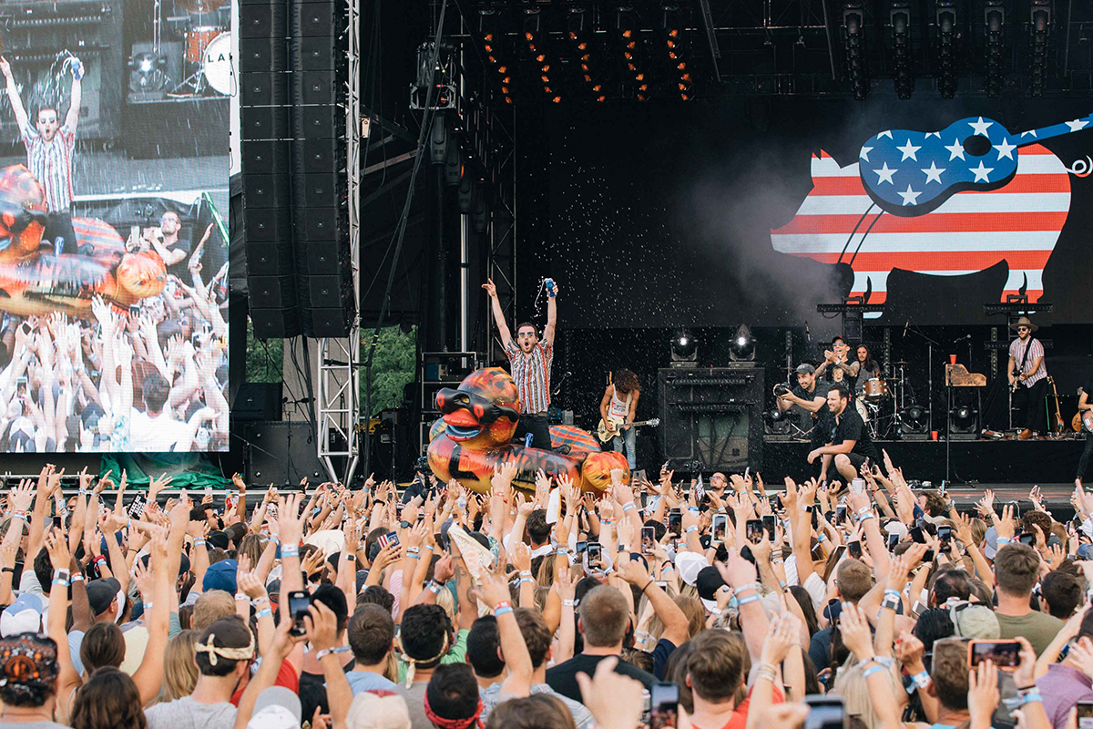 member of the band lacno crowd surfing on a pool float while drinking beer