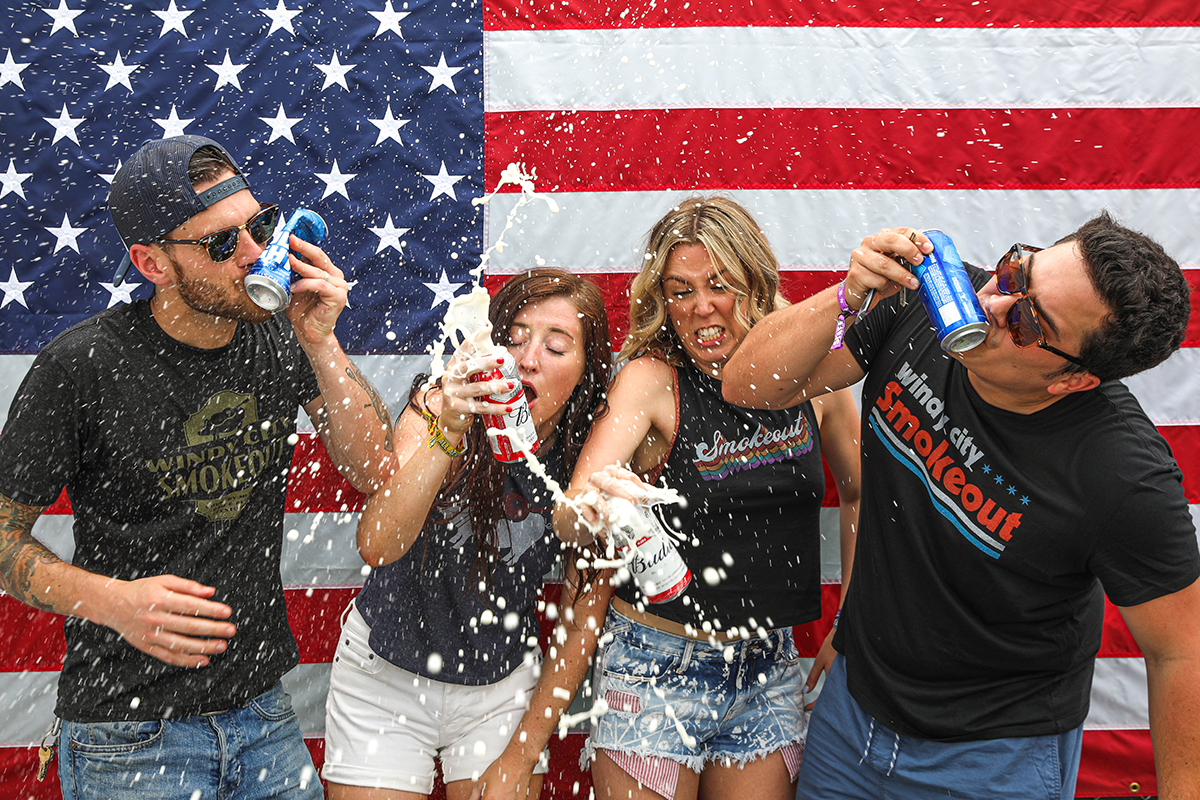 group of friends shaking up and shotgunning beers