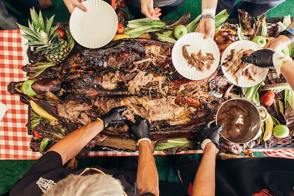 overhead shot of hands pulling apart pork and serving