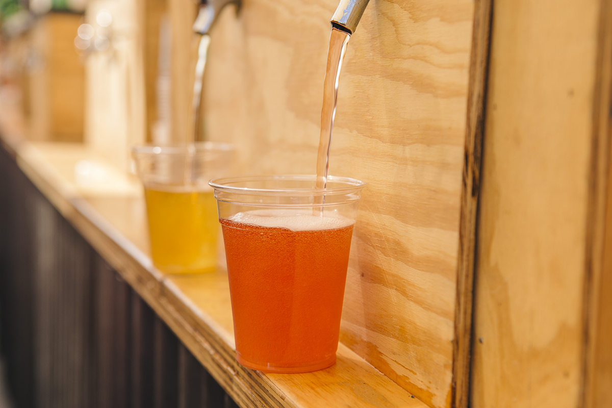 two cups of beer being poured from the tap