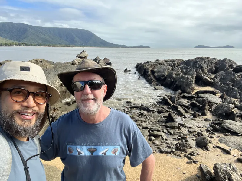 The two men in front of the rocks and the headland