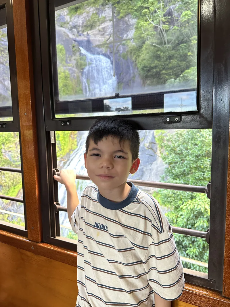 A boy at the window in front of Stoney Creek Falls