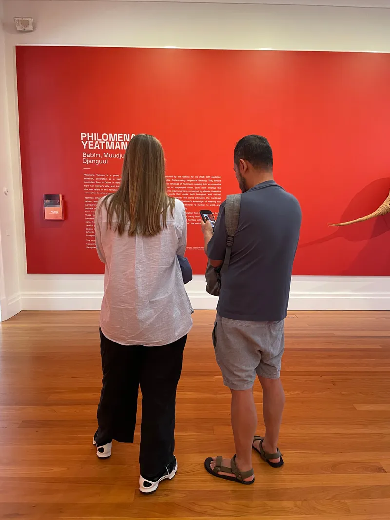 Two people standing in front of the red Philomena Yeatman wall