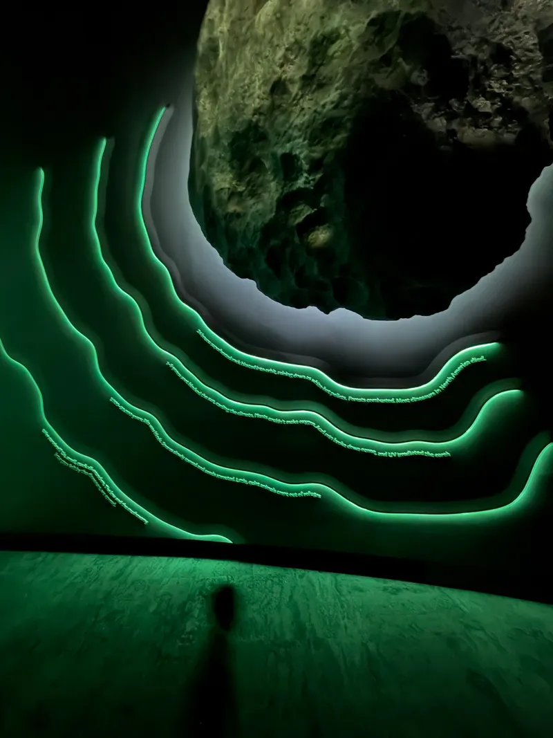 A glowing green asteroid hanging above curved bands of light