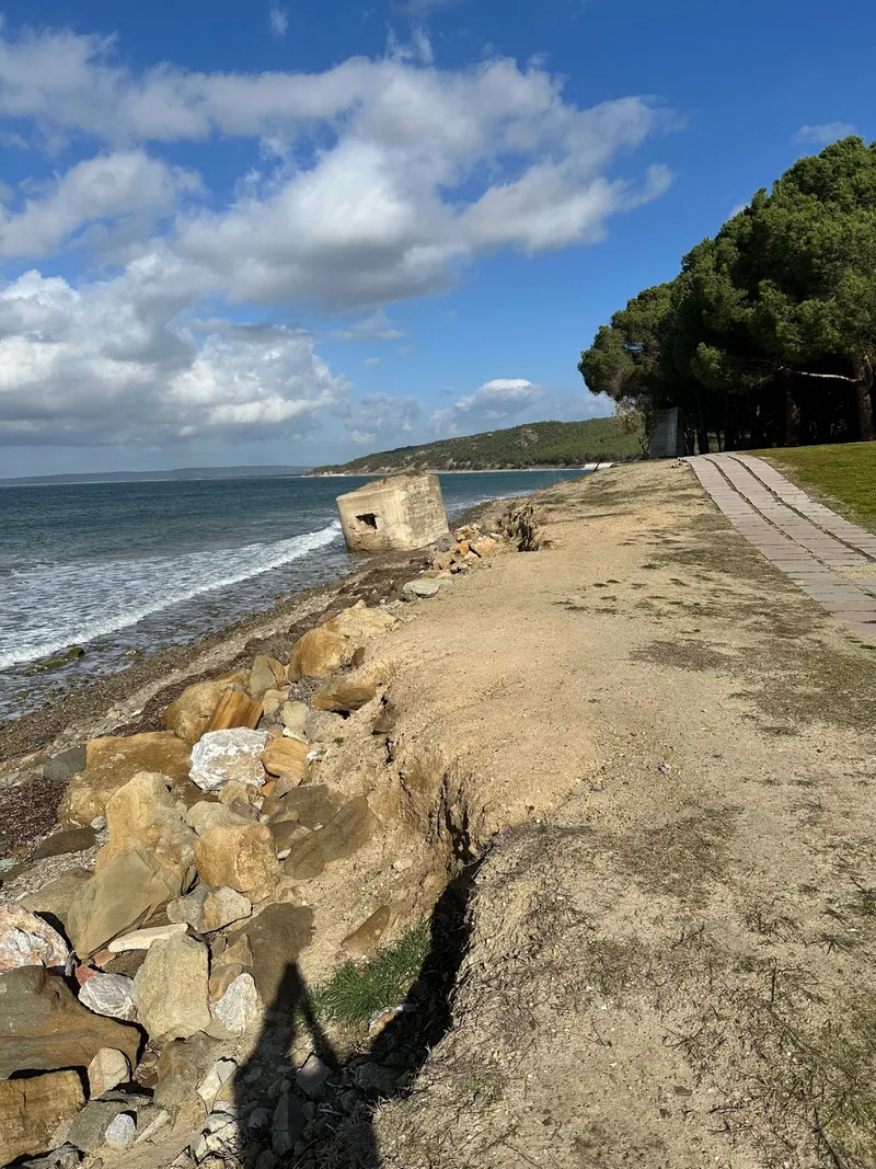 A coastal path above a rocky beach at Gallipoli, with Chris’s shadow
