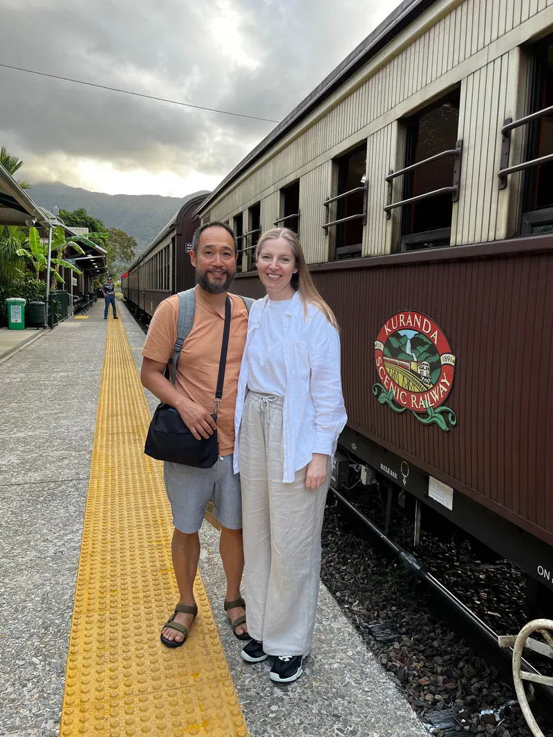 Two people beside the Kuranda Scenic Railway carriage