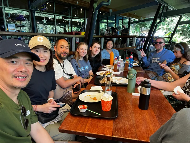 The whole group around a long lunch table in the cafe
