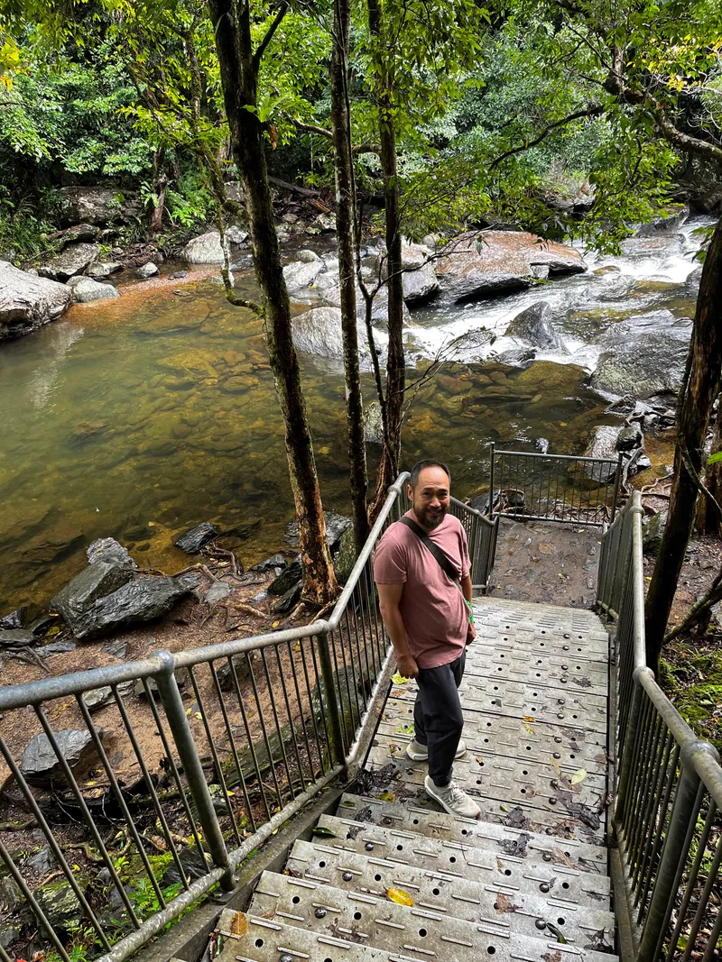 Eddie on the steel stairs down to the creek, with the cascades below