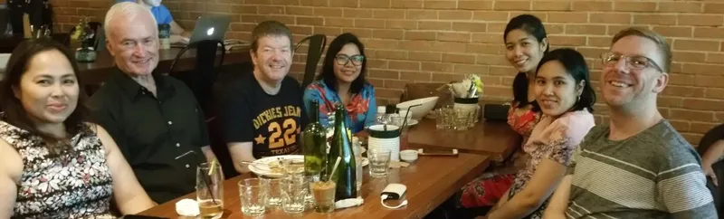 Chris and friends smiling around a restaurant table
