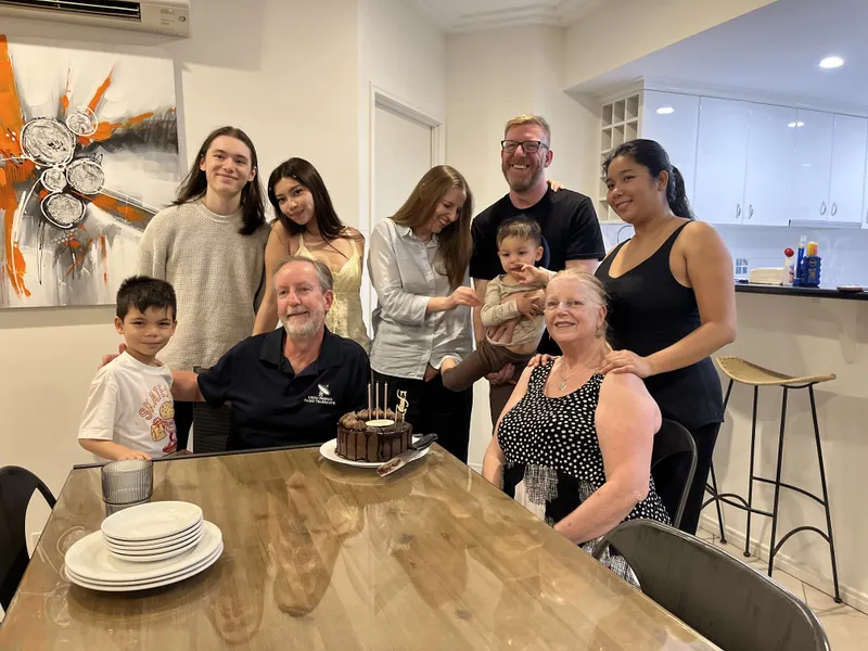 Everyone gathered around Steve and Lin and the chocolate birthday cake