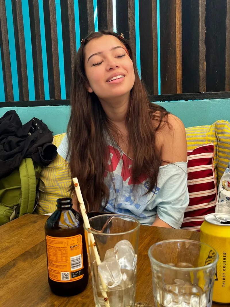 A girl with her eyes closed at a cafe table