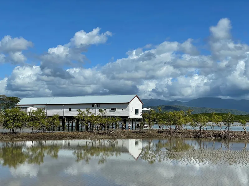 An old sugar wharf shed reflected in the still water