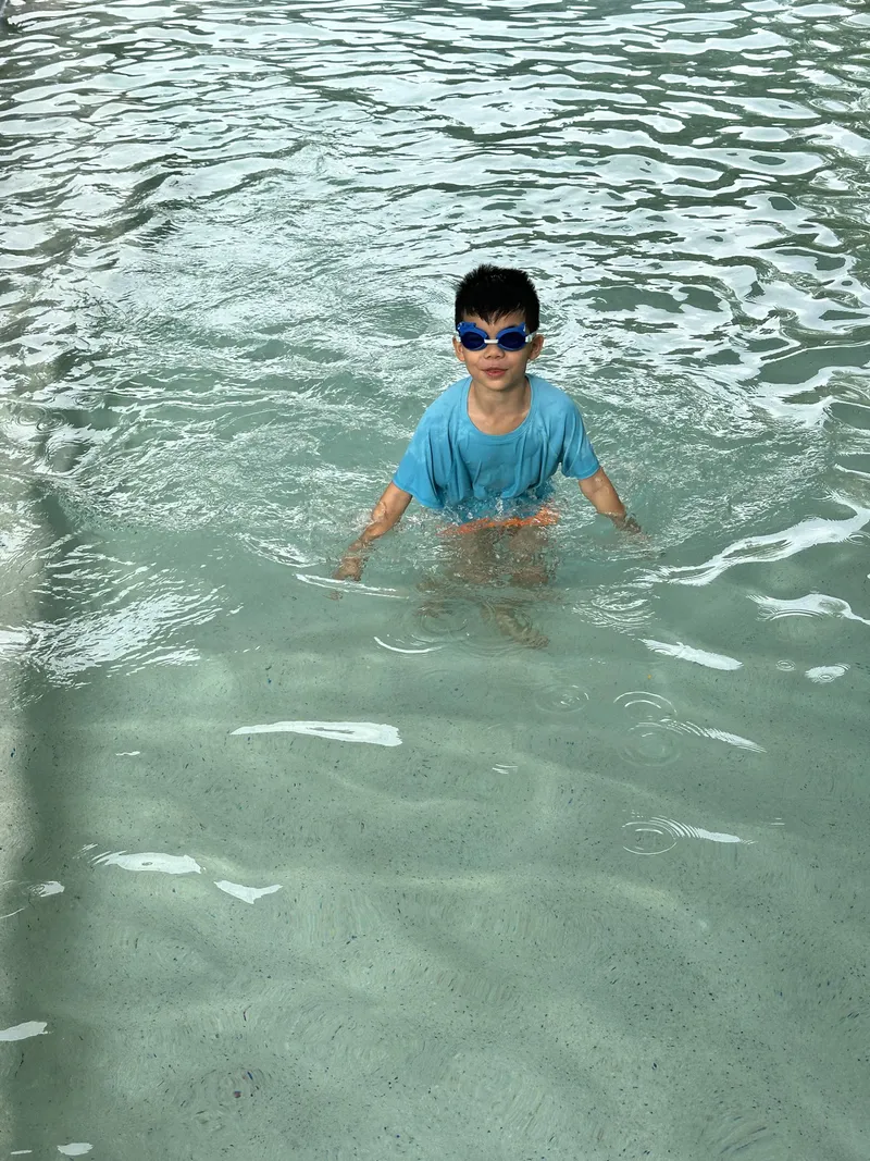 A boy in goggles swimming in the pool