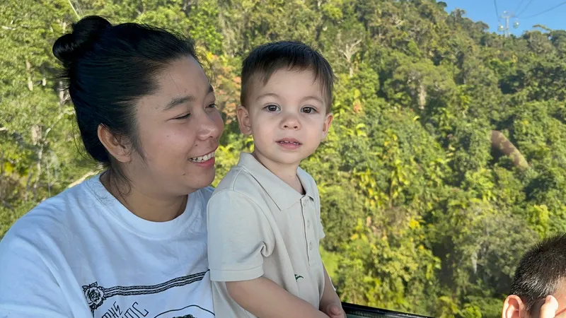 A woman holding a toddler at the gondola window