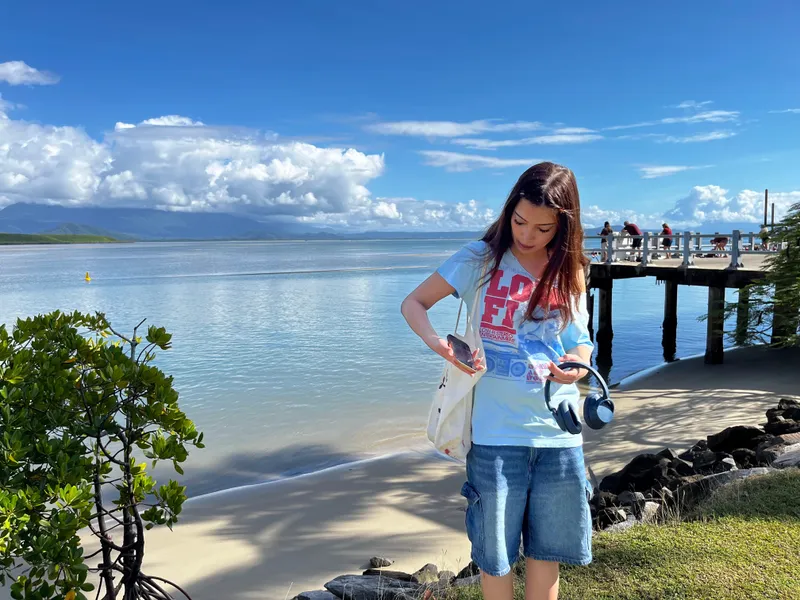 A girl checking her phone by the jetty