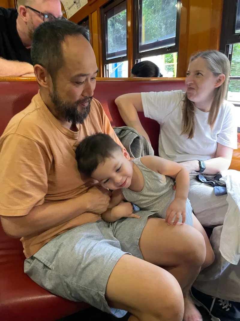 The toddler snuggled against the man, with a woman beside them